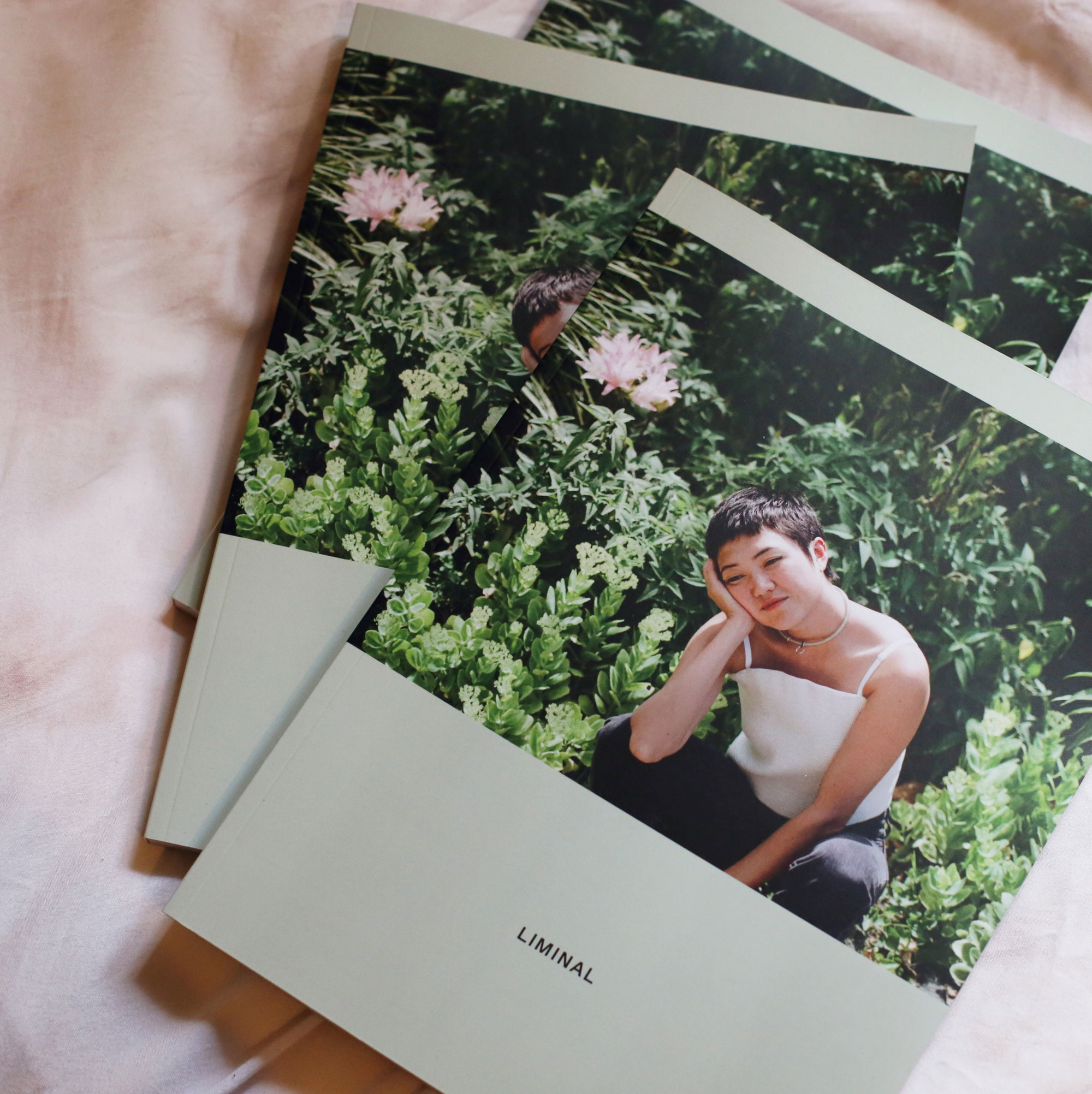 three copies of liminal magazine with asian woman posing in garden on cover